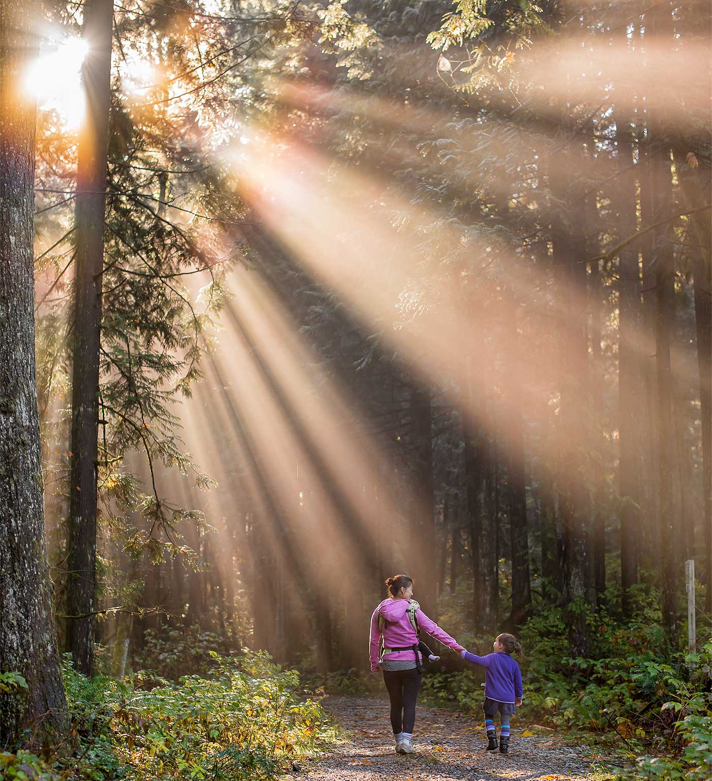 Una madre y su hija pasean por el bosque